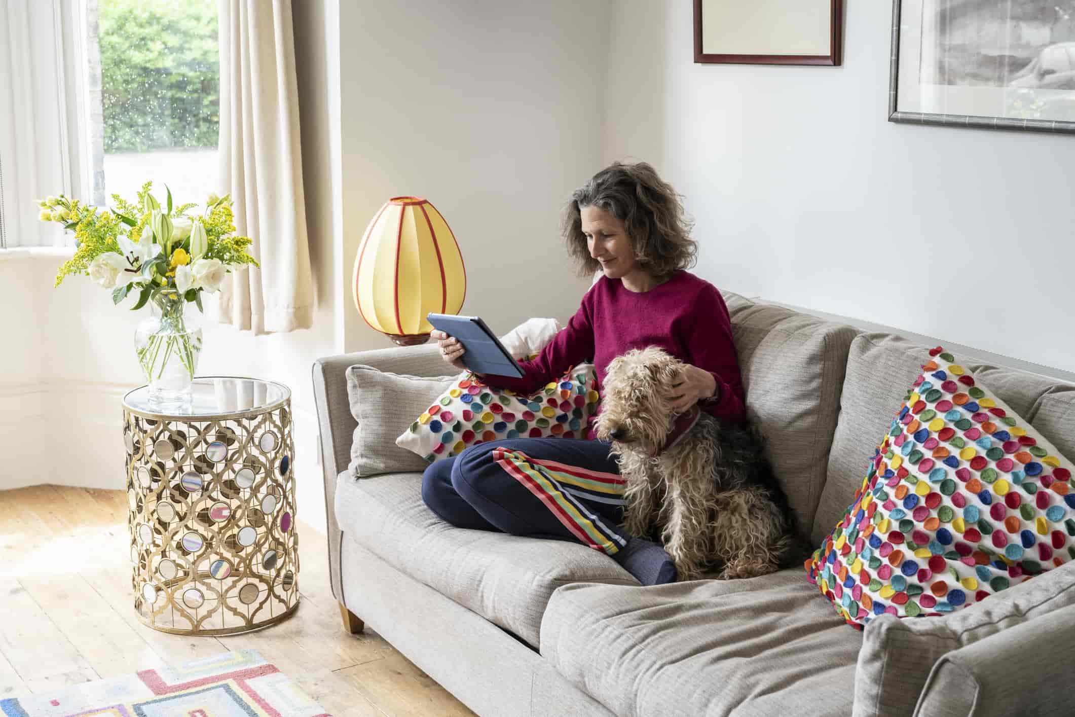 Woman sitting on couch with her dog