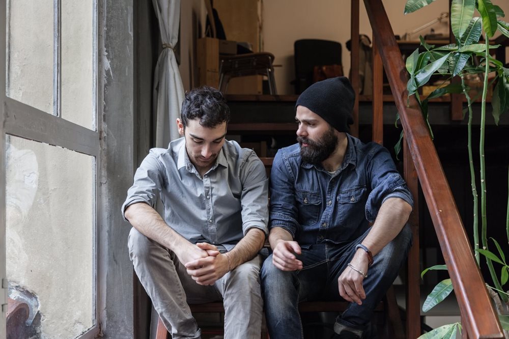 Two men talking on stairs